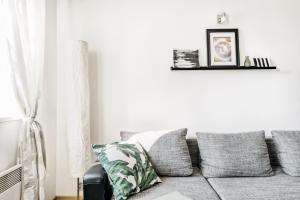 - un salon avec un canapé gris et des oreillers dans l'établissement LIL Apartment with Tyn Cathedral View, Parking & AC, à Prague 19 autres photos