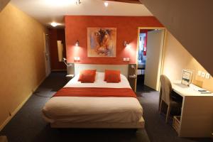 ein Hotelzimmer mit einem Bett und einem Schreibtisch in der Unterkunft Logis Le Bourguignon in Bèze