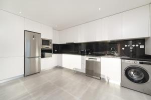 a white kitchen with a washer and a dishwasher at Lagoa Views - Holiday Apartment by SCH in Foz do Arelho