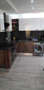 a kitchen with white cabinets and a washing machine at Résidence Inès Djerba Appartements VIP in Houmt Souk