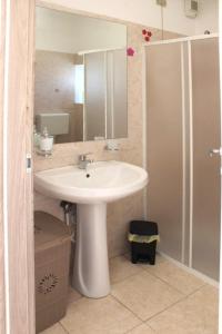 La salle de bains est pourvue d'un lavabo, d'un miroir et d'une douche. dans l'établissement B&B PLANET, à Roccella