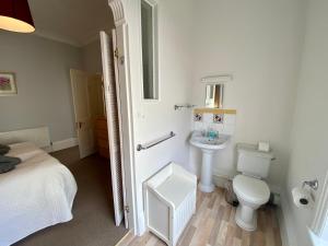 a white bathroom with a sink and a toilet at Merrifield House in Sidmouth