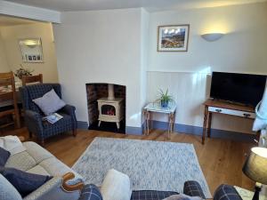 ein Wohnzimmer mit Couch und Kamin in der Unterkunft Longtail Cottage in Sidmouth