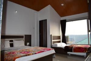 a bedroom with two beds and a large window at Hotel Soham Retreat in Mahabaleshwar +23 photos