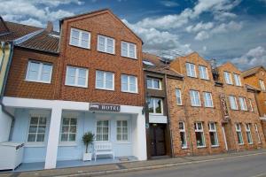 a row of buildings on a street with a hotel at Landhaus Hamm THE UNIQUE BOUTIQUE HOTEL in Düsseldorf