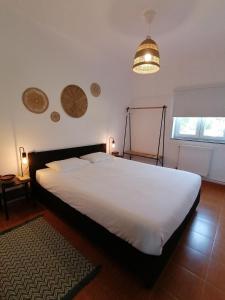 a bedroom with a large white bed and a lamp at Pine 3 Inn, holiday home, activities and more in Boavista dos Pinheiros