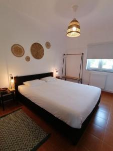 a bedroom with a large white bed and a lamp at Pine 3 Inn, holiday home, activities and more in Boavista dos Pinheiros