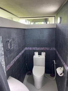 een badkamer met een toilet in een blauwe betegelde muur bij HINSAMAAN POOL VILLA in Koh Samui 
