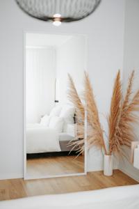 a bedroom with a white bed and a mirror at Moderne ruhige 2-Zimmer Wohnung in Coswig in Coswig