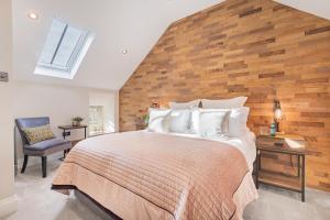 ein Schlafzimmer mit einem großen Bett und einer Holzwand in der Unterkunft Ivy Cottage with Hot tub! in Silverdale