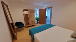 a bedroom with a bed and a chair in a room at Santa Cruz Villas in Santa Cruz das Flores