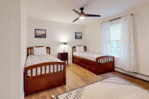 a bedroom with two beds and a ceiling fan at Golf2Beach Vacation Home in Old Orchard Beach