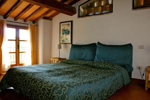 Un dormitorio con una cama con un edredón verde. en Centro Ippico Della Berardenga, en Castelnuovo Berardenga