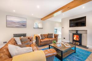 a living room with leather furniture and a fireplace at Ivy Cottage with Hot tub! in Silverdale