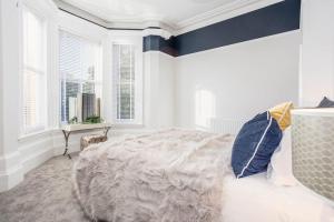 a white bedroom with a large bed and windows at Coppergate Mews Grimsby No.1 - 2 bed, 2 bath, ground floor apartment in Grimsby