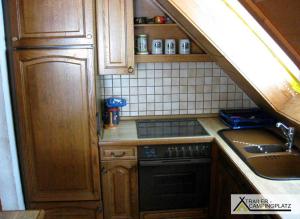 a small kitchen with a stove and a sink at Ferienwohnung Landzettel in Amorbach