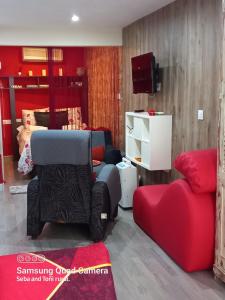a living room with a couch and a tv at Loft "Coqueto" Rojo in Ubrique
