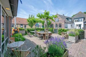 eine Terrasse mit Tisch, Stühlen und Blumen in der Unterkunft B&B Boutique Hotel De Waal in De Waal