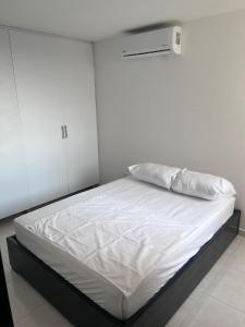 a bedroom with a white bed with a white sheets at SILVER PARK in Cúcuta