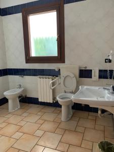 a bathroom with a toilet and a tub and a sink at Hotel Lory Ficarolo in Ficarolo