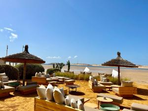 達赫拉的住宿－Lagon energy dakhla，海滩上带躺椅和遮阳伞的海滩