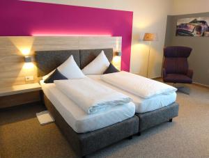 卡斯特勞恩的住宿－伯格斯塔特酒店，一间卧室配有一张大床和一把椅子