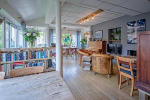 a living room with a piano and a dining room at B&B Hotel De Waal in De Waal