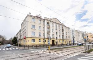 un edificio blanco y amarillo en una calle de la ciudad en Plac Narutowicza Two-Level Apartment, en Varsovia