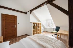 a bedroom with a bed and a desk and a window at Plac Narutowicza Two-Level Apartment in Warsaw