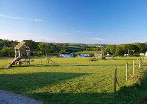 a park with a playground with two swings at Luxury 6 Bed Lodge with Hot Tub in Plymouth