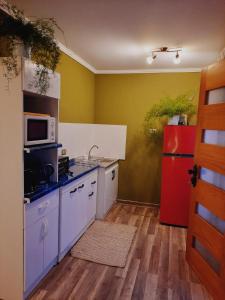 a kitchen with a red refrigerator and white cabinets at Cabaña Mi calma in Coquimbo