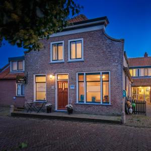 a brick house with a front door at night at B&B Hotel De Waal in De Waal