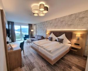 Wald Hotel Willingen في فيلنغن: غرفة نوم بسرير كبير وغرفة معيشة