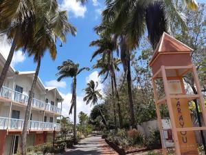 une rue en face d'un hôtel avec des palmiers dans l'établissement Ti colibri, à Les Trois-Îlets