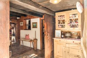 a kitchen with wooden walls and wooden cabinets and a table at Stoffelhäusl in Reith im Alpbachtal