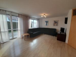 a living room with a black couch and a table at Sonnenparkhaus in Roth