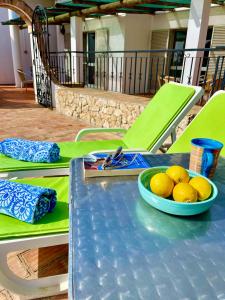 a blue table with a bowl of lemons on it at The Lemon Tree Villa in Moncarapacho