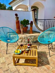 two blue chairs and a table on a patio at The Lemon Tree Villa in Moncarapacho