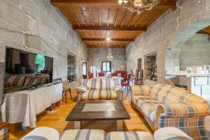 a living room with couches and a stone wall at Casa Rural Pazo San Damian in Amoeiro