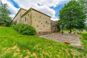 an external view of a stone building with a yard at Casa Rural Pazo San Damian in Amoeiro