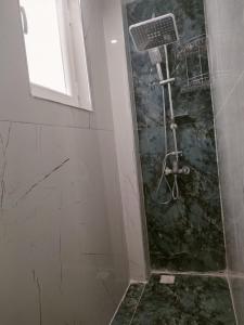 a shower stall in a bathroom with a window at Tekin Suit in Bandırma