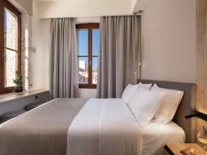 a hotel room with a bed and a window at Ethos Suites in Chania