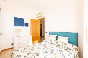 a bedroom with a bed with a blue headboard at Riviera Residence in Marina di Pietrasanta