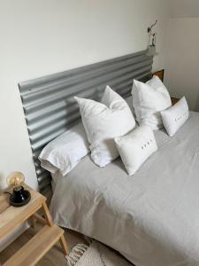 Una cama blanca con almohadas blancas. en les chambres de pauline appartements en Albertville