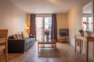 a living room with a couch and a tv at PREMIER SUITES Birmingham in Birmingham