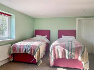 dos camas sentadas una al lado de la otra en una habitación en Applebarn en Lerryn