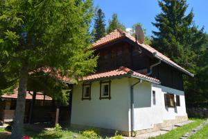 una pequeña casa con un árbol delante en Kućica za odmor '' Idila '' en Mitrovac