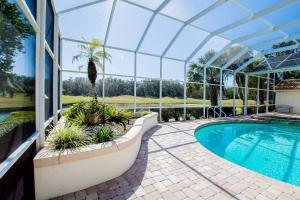 a swimming pool in a glass house with a swimming poolvisor at Fairway Haven in Wesley Chapel