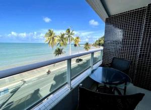 a balcony with a table and a view of the beach at Home service na praia de Cabo Branco in João Pessoa