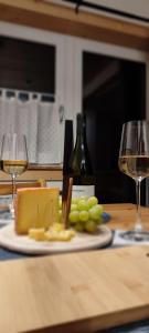 un plato de queso y uvas en una mesa con copas de vino en Ferienhaus Lechtaler Alpen, en Bach